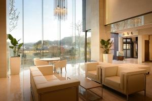 a lobby with chairs and a table in a building at Hotel Sun Hitoyoshi in Hitoyoshi