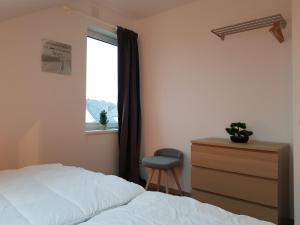 ein Schlafzimmer mit einem Bett, einer Kommode und einem Fenster in der Unterkunft Ferienwohnung am Dörnberg in Calden