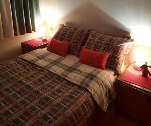 1 dormitorio con 1 cama con 2 almohadas rojas en Zeleni brig, en Mrkopalj