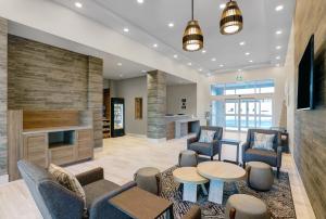 a lobby with chairs and tables and a fireplace at Candlewood Suites - Kingston West, an IHG Hotel in Kingston