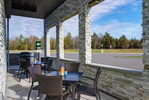 a patio with tables and chairs and a parking lot at Candlewood Suites - Kingston West by IHG in Kingston