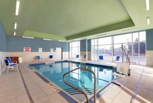 - une grande piscine d'eau bleue dans un bâtiment dans l'établissement Candlewood Suites - Kingston West, an IHG Hotel, à Kingston