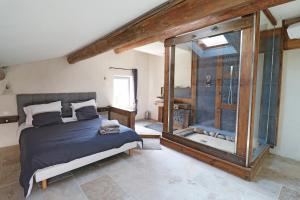 a bedroom with a bed and a glass shower at Appartement de charme Sud Luberon classé 4 étoiles in Puyvert