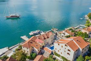 uma vista aérea de uma cidade sobre a água com um barco em Palazzo Radomiri Heritage Boutique Hotel em Kotor