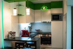 a kitchen with white cabinets and a black counter top at Apartman Amor in Tuzla