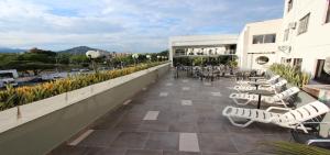 a balcony with lounge chairs and tables on a building at Hotel San Fernando Real in Cali