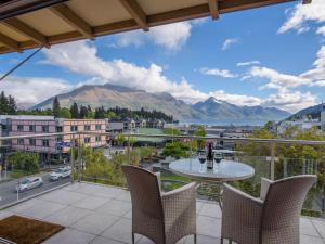 d'un balcon avec une table, des chaises et des montagnes. dans l'établissement Chambers City Centre Penthouse, à Queenstown