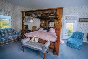 Rabbit Creek Bed & Breakfast في Versailles: غرفة نوم بسرير كبير وكرسي