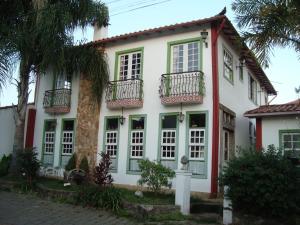 a white house with windows and balconies at Pousada Joaninha in Tiradentes