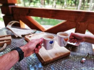 two people holding cups of coffee on a table at Łosia Chata in Grzybowce