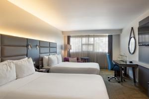 a hotel room with two beds and a desk at Crowne Plaza San Jose La Sabana, an IHG Hotel in San José