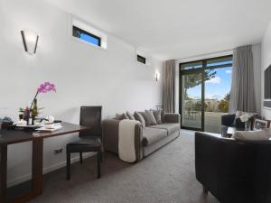 a living room with a couch and a table at Lake Avenue Studio in Queenstown