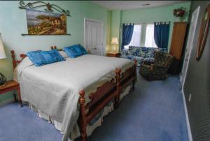 a bedroom with a large bed with blue pillows at Rabbit Creek Bed & Breakfast in Versailles