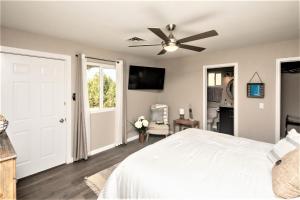 a bedroom with a white bed and a ceiling fan at NEW! Family Lake Havasu Home Close To Off-Roading And London Bridge! in Lake Havasu City
