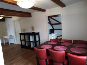a dining room with a table and red chairs at Lechwirt in Schongau