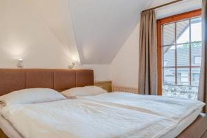 um quarto com uma cama grande e uma janela em Schmiedestrasse 3 Wohnung 7 em Scharbeutz
