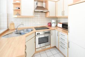 uma cozinha com um lavatório e um fogão em Sperlingslust em Scharbeutz