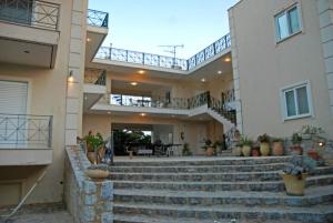 a large house with stairs in front of it at Areti & Maria Apartments in Gythio