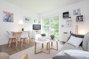 ein Wohnzimmer mit einem Sofa und einem Tisch in der Unterkunft Apartmentanlage Wennseestraße Kleines Glück in Scharbeutz