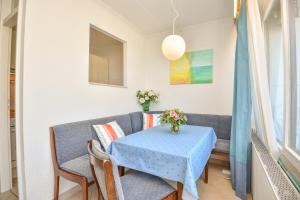 une salle à manger avec une table bleue et des chaises dans l'établissement Terrassenhügel App 106, à Scharbeutz