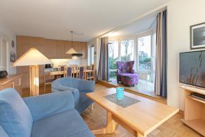 ein Wohnzimmer mit einem blauen Sofa und einem Tisch in der Unterkunft Witthus Wohnung 2 in Scharbeutz