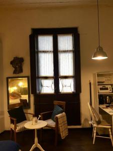 sala de estar con ventana, mesa y sillas en Estudio Taller de Tejas Colonia B&B, en Colonia del Sacramento