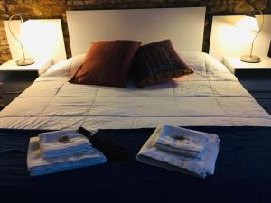 1 cama con 2 toallas y 2 lámparas en Estudio Taller de Tejas Colonia B&B, en Colonia del Sacramento