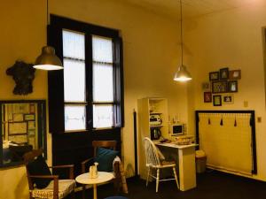 Zimmer mit einem Tisch, Stühlen und einem Fenster in der Unterkunft Estudio Taller de Tejas Colonia B&B in Colonia del Sacramento