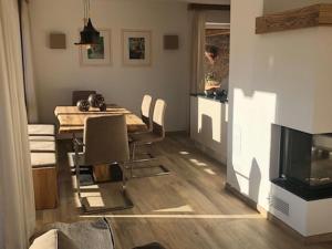 a dining room with a table and chairs and a television at Luxury chalet with 3 bathrooms, near small slope in Neukirchen am Großvenediger