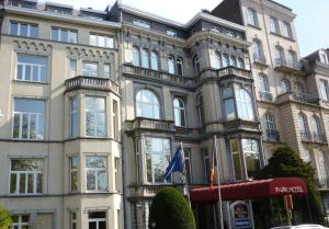 un grand bâtiment avec un drapeau devant lui dans l'établissement Best Western Plus Park Hotel Brussels, à Bruxelles