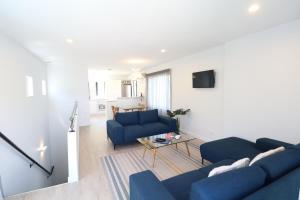 a living room with two blue couches and a tv at Close to the Action - In Town - Spa Pool in Queenstown