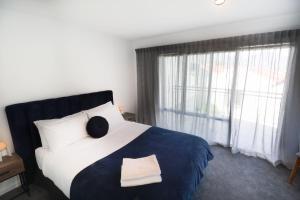 a bedroom with a large bed and a window at Close to the Action - In Town - Spa Pool in Queenstown