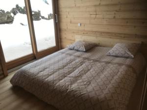 a bedroom with a bed and two windows at La grange à Gaspard in Allemont