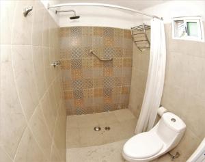 La salle de bains est pourvue d'une douche, de toilettes et d'un rideau de douche. dans l'établissement Hotel El Paraíso, à Armería