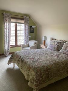 een slaapkamer met een groot bed en een raam bij Cedar Gables Bed & Breakfast in Niagara on the Lake