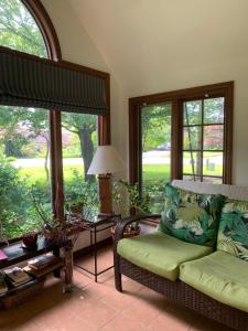 a living room with a couch and large windows at Cedar Gables Bed & Breakfast in Niagara-on-the-Lake