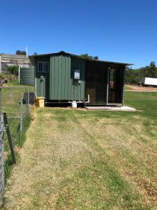 米尔顿Walsh Farm Shepherd’s Rest的绿色建筑,在田野上设置围栏