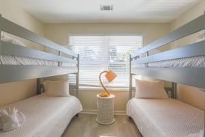 two bunk beds in a room with a window at Beachside Cottage in Isle of Palms