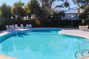 une grande piscine avec des chaises dans un complexe hôtelier dans l'établissement Beachside Cottage, à Isle of Palms