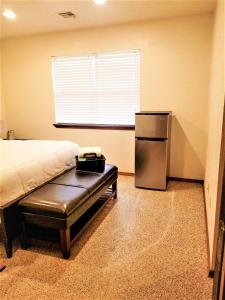 a bedroom with a bed and a small refrigerator at Near to OUHSC Hospitals-Garage Studio in Oklahoma City