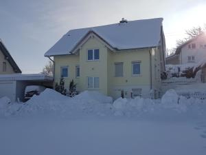 a house covered in snow with a pile of snow at Ferienwohnung Dressler in Wolfegg