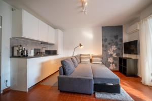 een woonkamer met een bank en een keuken bij Appartement à quelques pas de la mer WIFI CLIM PARKING in La Grande-Motte