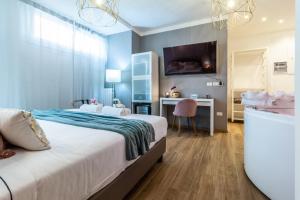 1 dormitorio con 1 cama, escritorio y TV en 4 Star Suite SPA - Self Check-In en Bolonia