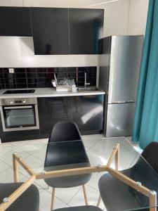 a kitchen with two chairs and a stainless steel refrigerator at F2 Lamentin in Le Lamentin