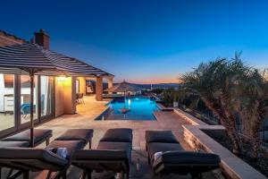 Un patio con tumbonas y una piscina. en VIEWS! Luxury Lake Home W/ Pool, Spa & Fire Pit!, en Lake Havasu City