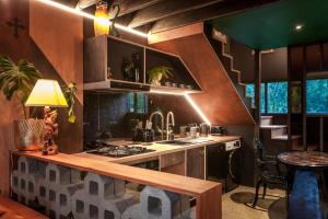 a kitchen with a sink and a stove top oven at The Barn, designers dream beach hideaway in Waihi Beach +13 photos
