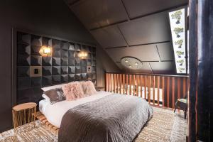 una camera con un grande letto e una finestra di The Barn, designers dream beach hideaway a Waihi Beach