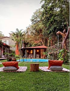 een tuin met 2 stoelen en een zwembad bij Kûara Pipa in Pipa