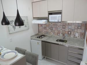 uma cozinha com um lavatório e um micro-ondas em Apartamento mobiliado novo Metrô Luz em São Paulo