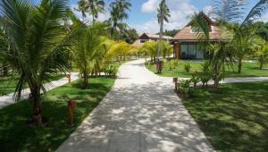 ein Spazierweg in einem Resort mit Palmen in der Unterkunft Flat 113 Eco Resort Praia dos Carneiros in Praia dos Carneiros